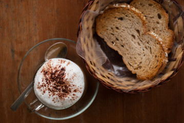A cup of hot cappuccino and bread