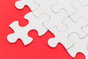 Fototapeta premium Plain white jigsaw puzzle on red background