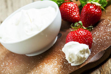 Fresh strawberries with cream, selective focus