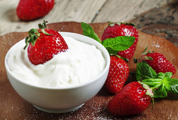 Fresh strawberries with cream, selective focus