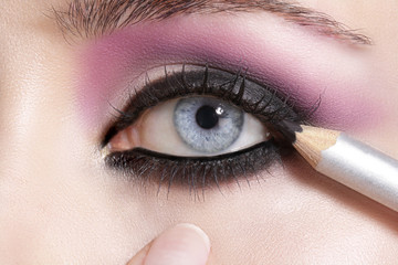 Naklejka premium Close up on eyes , making colorful eyeshadows and eyeliner