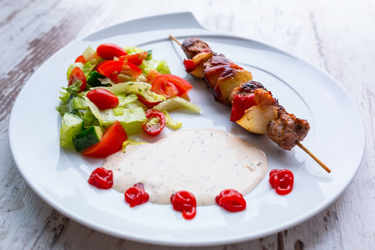 Grilled duck shashlik with salad on the plate