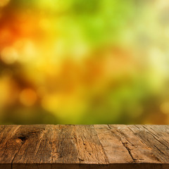 Wooden table with autumn background