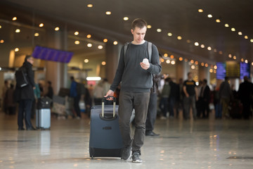 Young traveler using mobile phone in airport