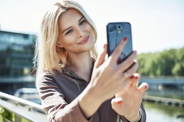 Foto auf Acrylglas Porträt einer blonden Frau, die ein Selfie macht © konradbak
