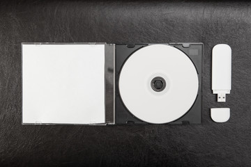 DVD disc in box on black leather background. Mock-up