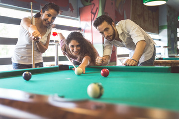 group of friends playing pool - obrazy, fototapety, plakaty