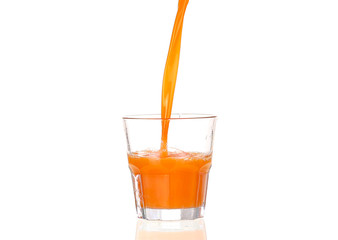Juice pouring into glass isolated on white
