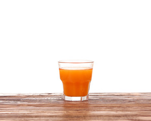 Carrot juice in glass with fresh organic carrots on white wooden table