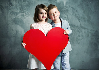 Obraz na płótnie Canvas Two kids holding a giant heart