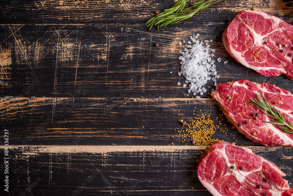 Wall mural raw meat steak on dark wooden background ready to roasting