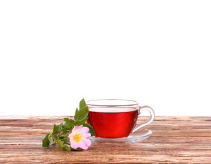 Herbal tea in a glass cup, fresh flowers on a background 