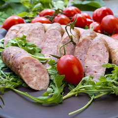 Smoked sausages with herbs, greens,  tomatoes
