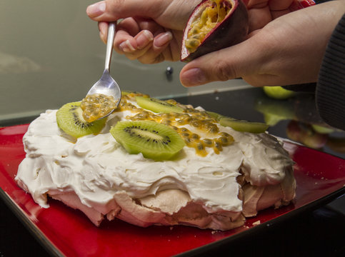 spooning passionfruit on pavlova