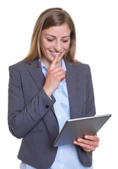 Geschäftsfrau im grauen Blazer liest am Tablet