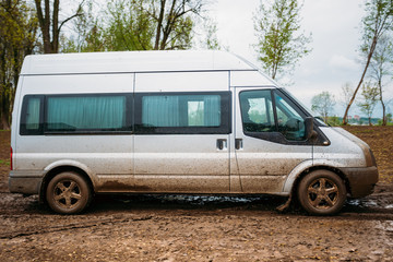Fototapeta premium Very Dirty Car Minivan Stalled In The Mud.