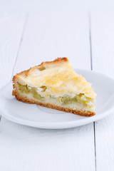 Slice of rhubarb pie on wooden table.