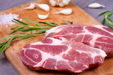 Fresh meat with rosemary on wooden background