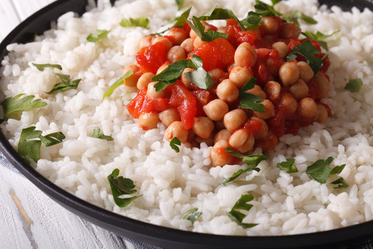Rice with chickpeas, tomatoes and herbs close-up. Horizontal
