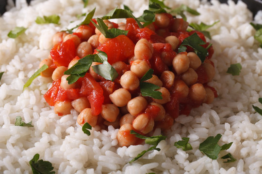 Rice with chickpea curry and herbs macro background