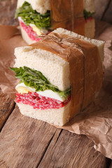 rustic sandwiches with salami, salad and eggs close-up 