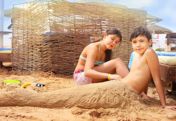 preteen siblings brother and sister have fun on sand beach play