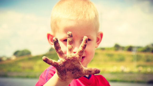 Child Playing Outdoor Showing Dirty Muddy Hands.