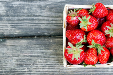 Ripe strawberries in wooden box over wooden table