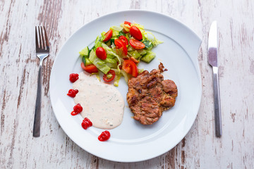 Grilled pork steak with salad on the plate
