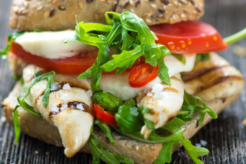 Chicken sandwich with crispy baguette  on a wooden background 