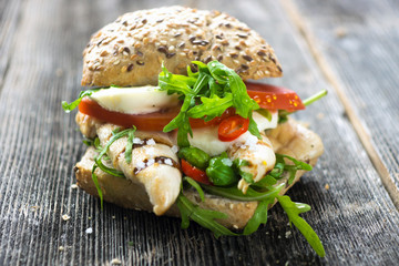 Chicken sandwich with crispy baguette  on a wooden background 