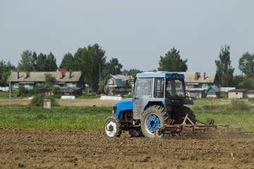 The tractor in the field on agricultural operations.