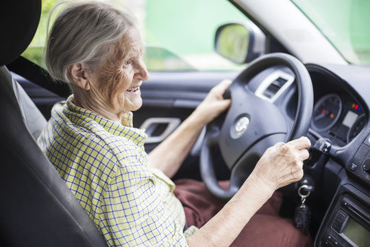 Cheerful senior woman driving a car 
