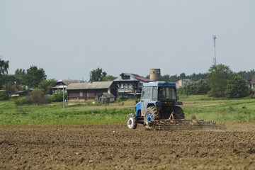 The tractor in the field on agricultural operations.