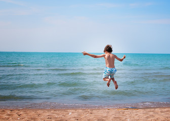 young boy jumping into a lake