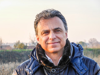 Elegant man with dark padded jacket in the countryside