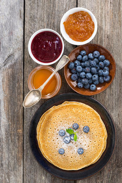 crepes with fresh blueberries, jams and honey, top view