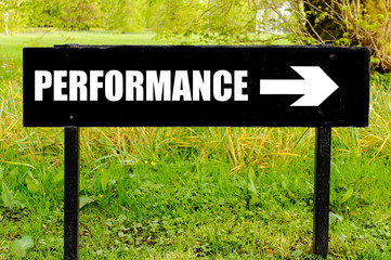 PERFORMANCE written on directional black metal sign