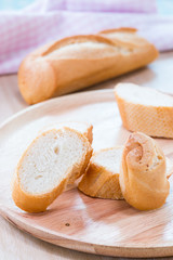 Sliced french bread baguette on wooden plate.Soft focus style
