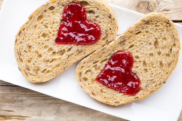 Grain slice of bread with jam heart shape.