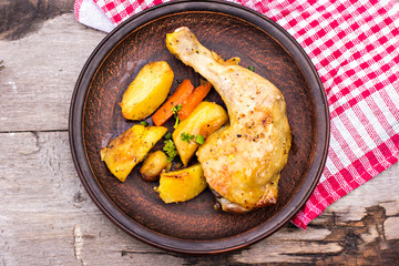 Baked chicken pieces with potatoes, herbs and garlic 