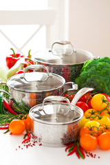 Set of metal pots cookware and fresh vegetables, selective focus