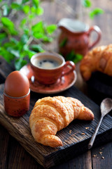 Croissant on a wooden cutting board, selective focus