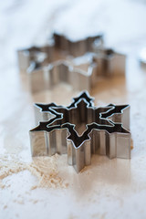 Gingerbread metallic snowflake form on white table, soft focus
