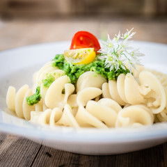 Noodles with vegan pesto and colorful tomatoes. Selective focus.