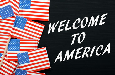 Welcome to America on a blackboard with USA flags
