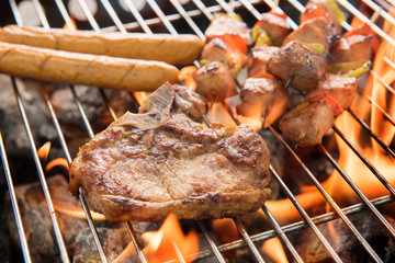 Assorted delicious grilled meat over the coals on a barbecue.
