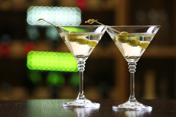 Glasses of cocktails on bar background