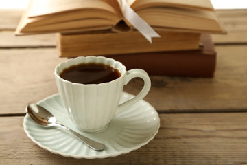 Still life with cup of coffee and books, on wooden table