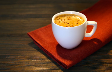 Cup of coffee on napkin on table close up